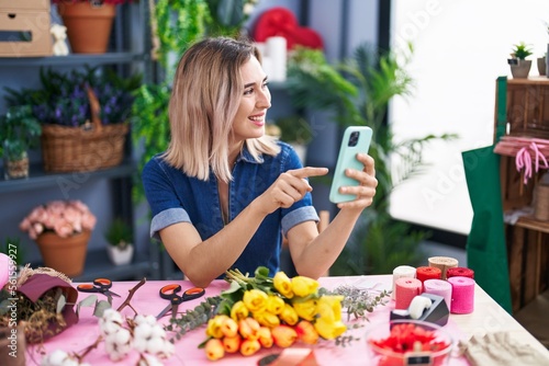 Young woman florist smiling confident using smartphone at florist