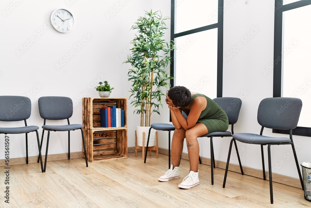 Young hispanic woman desperate sitting on chair at waiting room