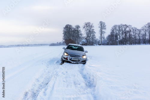 A gray car crashed on a slippery and snowy road on a winter day. © Jorens