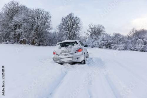 A gray car crashed on a slippery and snowy road on a winter day.