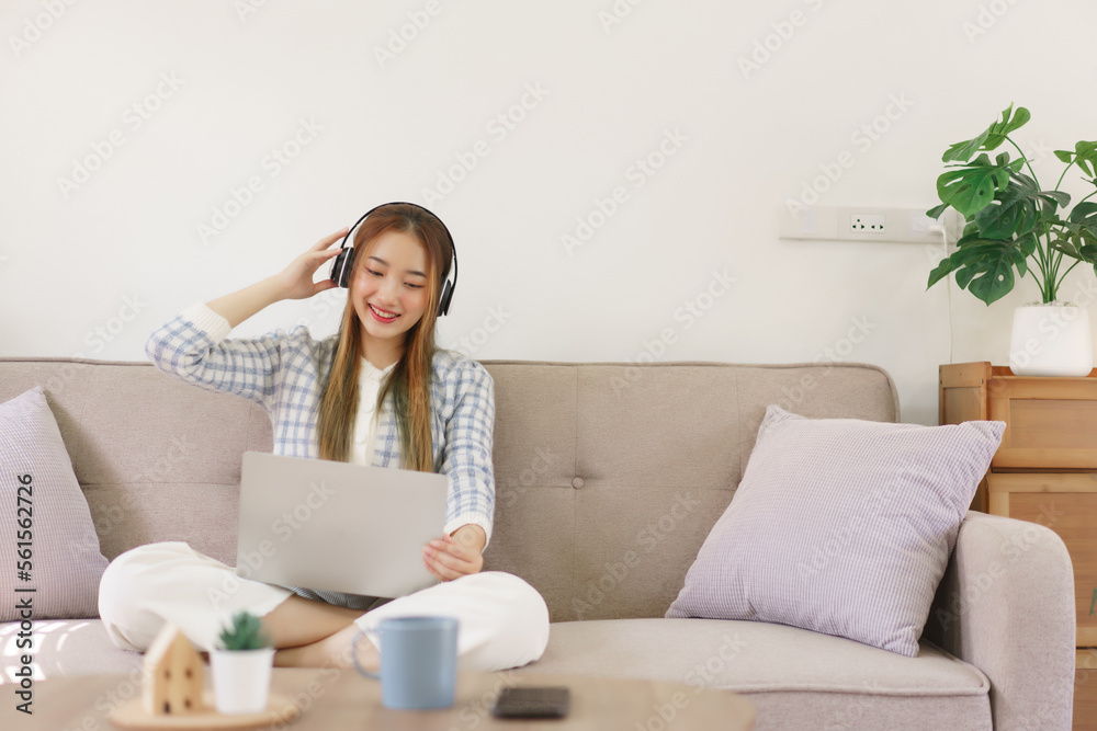 Leisure time concept, Women sitting on comfortable couch and wearing headphone to watching movie Leisure time concept, Women sitting on comfortable couch and wearing headphone to watching movie