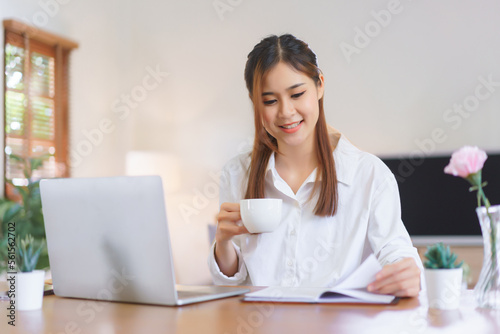 Working at home concept, Women drinking coffee and reading book while working at modern home office © snowing12