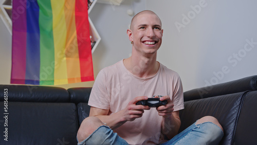 Smiling queer man playing video games with a consol indoor. High quality photo photo