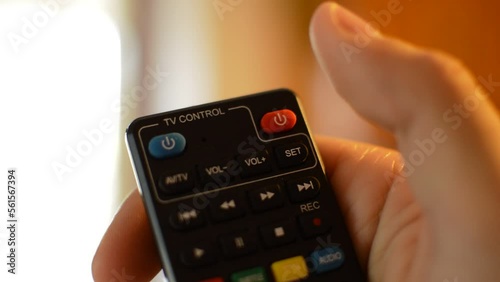 young caucasian man's hand use the tv remote to switch television's channels