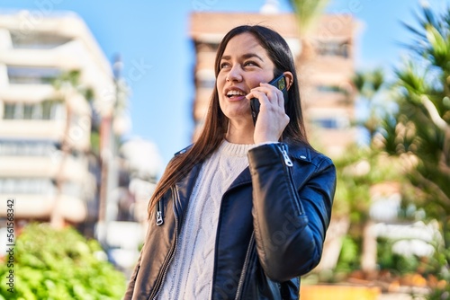 Young woman smiling confident talking on the smartphone at park