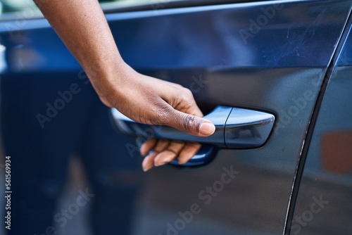 Canvas Print African american woman opening car door at street
