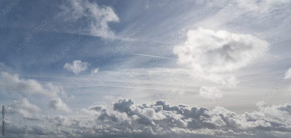 Dramatic, sunlit, cumulus clouds with aeroplane contrail. Dramatic, sunlit, cumulus clouds with aeroplane contrail.