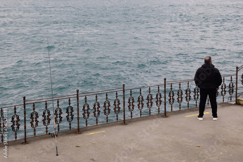 Man waiting to fish in cold weather in kandilli Istanbul, turkey photo