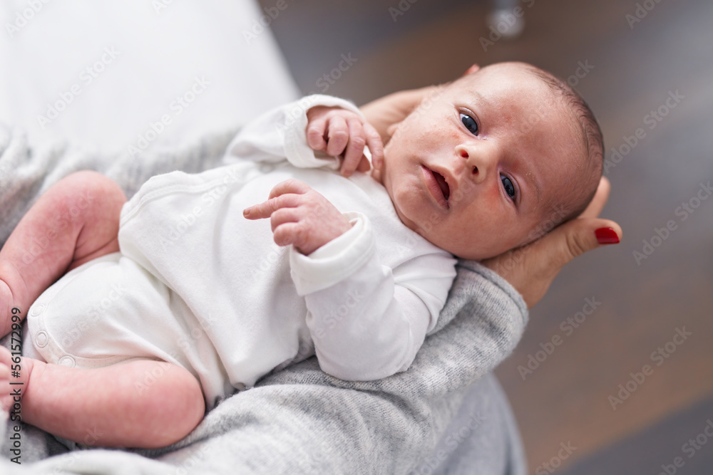 Adorable caucasian baby on mother arms at home Adorable caucasian baby on mother arms at home