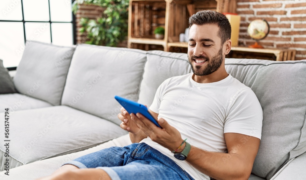Young hispanic man smiling confident using touchpad at home Young hispanic man smiling confident using touchpad at home