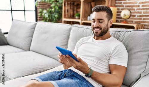 Young hispanic man smiling confident using touchpad at home