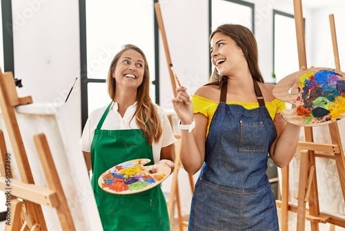 Mother and daughter smiling confident drawing at art studio