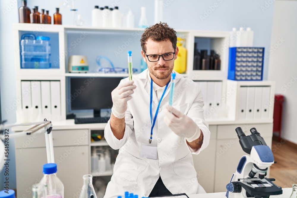 Young hispanic man scientist holding test tubes at laboratory Young hispanic man scientist holding test tubes at laboratory