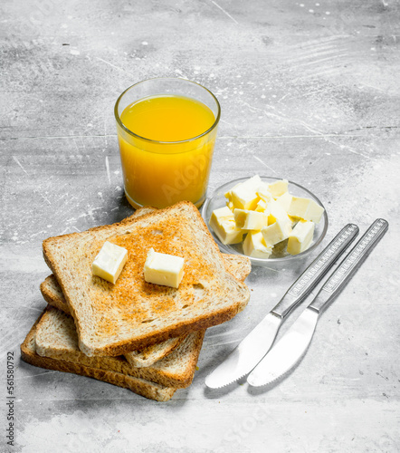 Breakfast. Toasted bread with butter and a glass of orange juice. photo