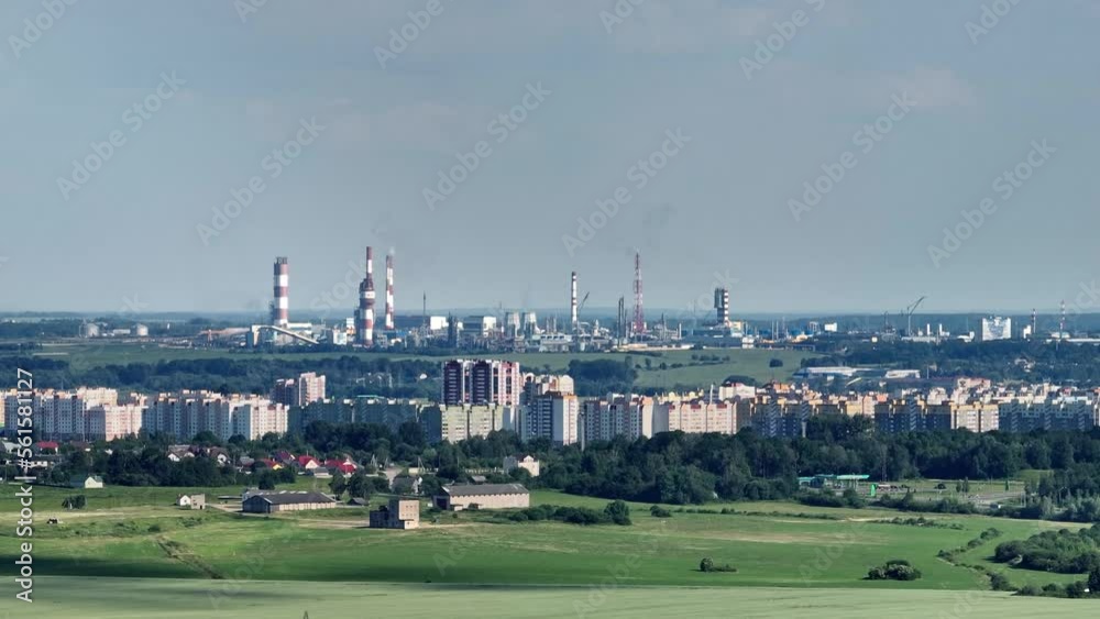 ariel panoramic view of city and skyscrapers with a huge factory with smoking chimneys in the background