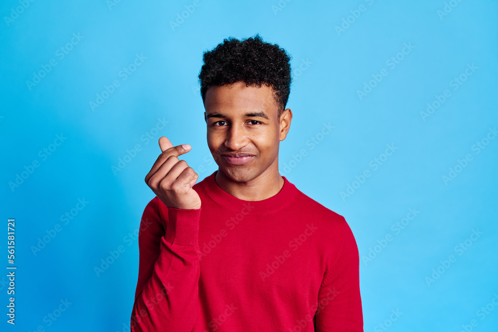 Cheerful black man pointing at camera doing money signal Cheerful black man pointing at camera doing money signal