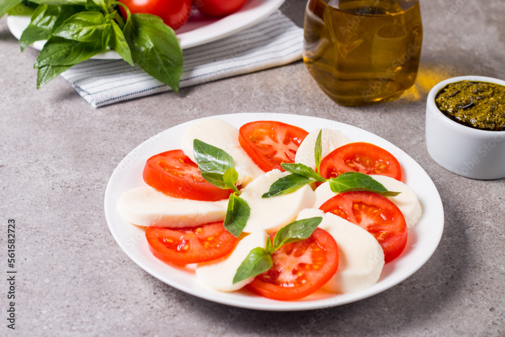 Close-up photo of caprese salad with ripe tomatoes, basil, buffalo mozzarella cheese. Italian and Mediterranean food concept. Fresh and healthy organic meal. Starter and antipasti. 