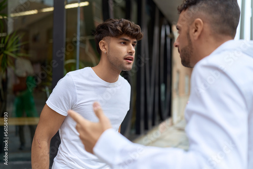 Two hispanic men couple arguing at street