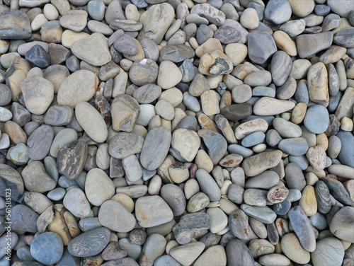 graphic resource of rounded sea stones in gray and brown shades with a beautiful texture full frame, building mineral material of round river cobblestones scattered on a flat surface