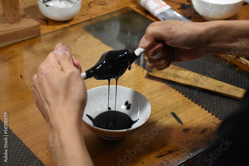 Filtration of Japanese lacquer urushi to remove dust particles - preparation of raw material to create luxurious and glossy traditional lacquerware photo