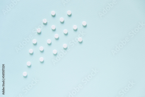 Scattered white pills on blue table. Mock up for special offers as advertising  web background or other ideas. Medical  pharmacy and healthcare concept. Copy space. Empty place for text or logo