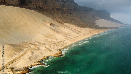 Drone view of blue ocean and sand at golden hour