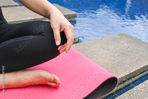 Young healthy woman in sportive top and leggings practicing yoga at home sitting in lotus pose on yoga mat meditating relaxed,Mindfulness meditation, self love, self care, new year resolution concept © joy