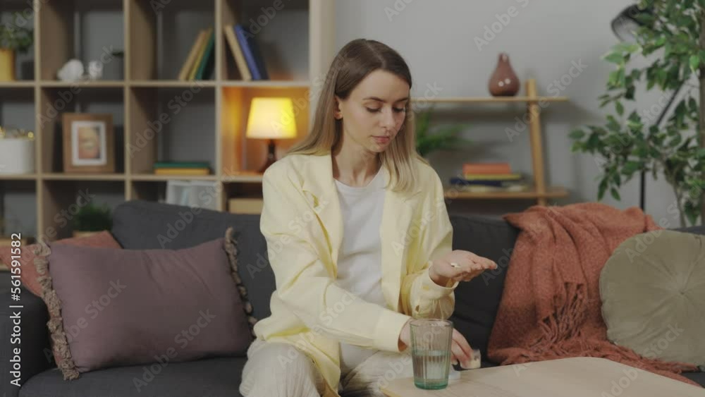 Young pregnant woman taking daily medicine, pills or complex of vitamins while sitting on comfy couch at home. Healthcare, pregnancy and treatment concept Young pregnant woman taking daily medicine, pills or complex of vitamins while sitting on comfy couch at home. Healthcare, pregnancy and treatment concept