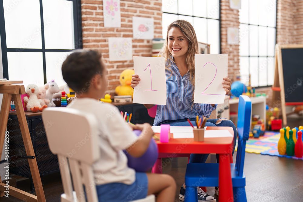 Obraz premium Teacher and toddler sitting on table having maths lesson at kindergarten