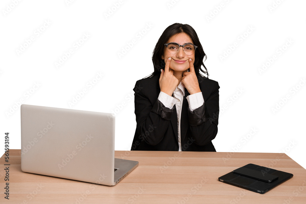 Young indian woman in a table with a laptop and tablet isolated doubting between two options. Young indian woman in a table with a laptop and tablet isolated doubting between two options.