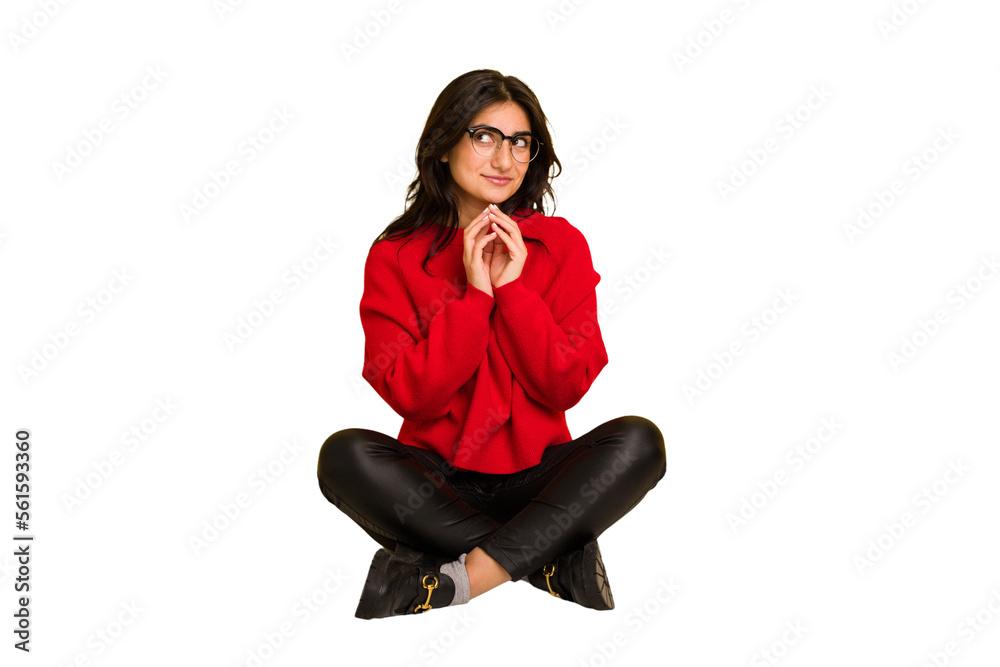 Young indian woman sitting on the floor cut out isolated making up plan in mind, setting up an idea. Young indian woman sitting on the floor cut out isolated making up plan in mind, setting up an idea.
