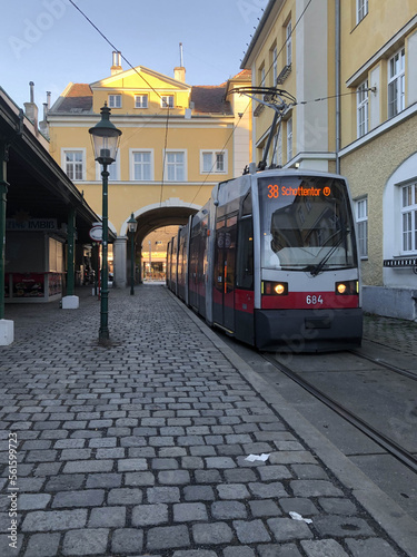 Tram stop with an archway in Vienna old town and a tram pulls up