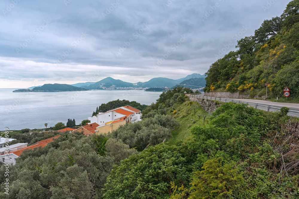 Mountain road running along the sea with a beautiful view. Traveling by car in Montenegro.