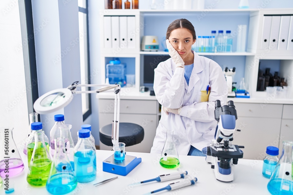 Young brunette woman working at scientist laboratory thinking looking tired and bored with depression problems with crossed arms. Young brunette woman working at scientist laboratory thinking looking tired and bored with depression problems with crossed arms.