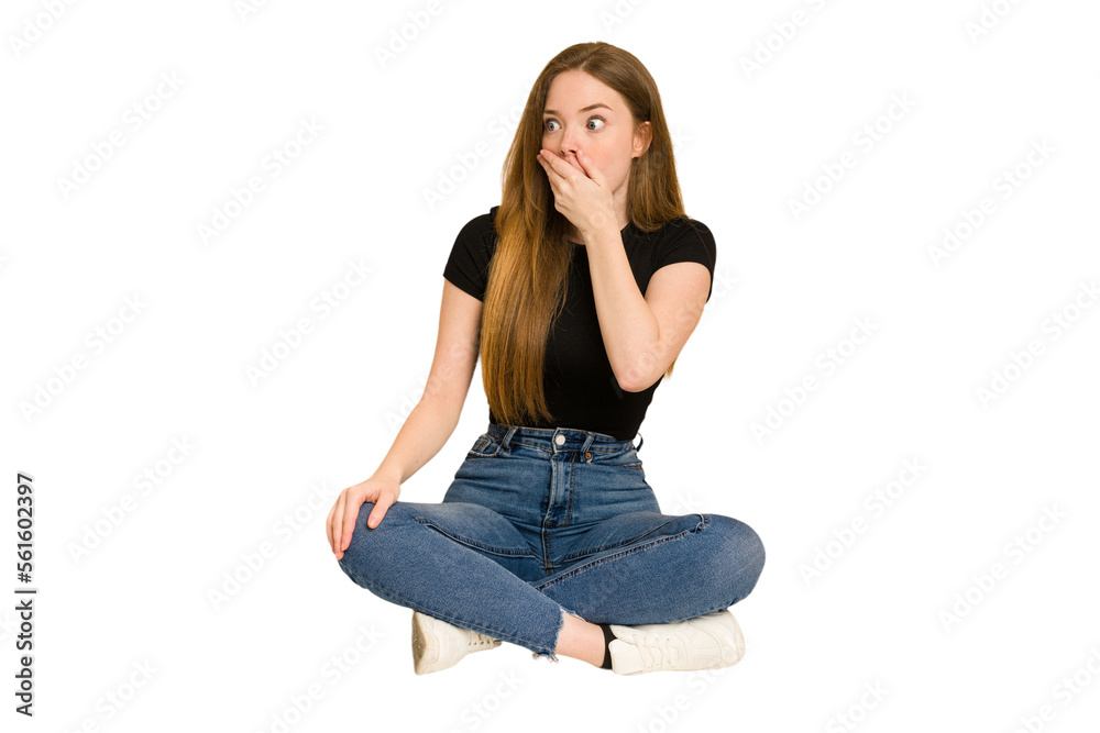Young redhead woman sitting on the floor cut out isolated thoughtful looking to a copy space covering mouth with hand. Young redhead woman sitting on the floor cut out isolated thoughtful looking to a copy space covering mouth with hand.