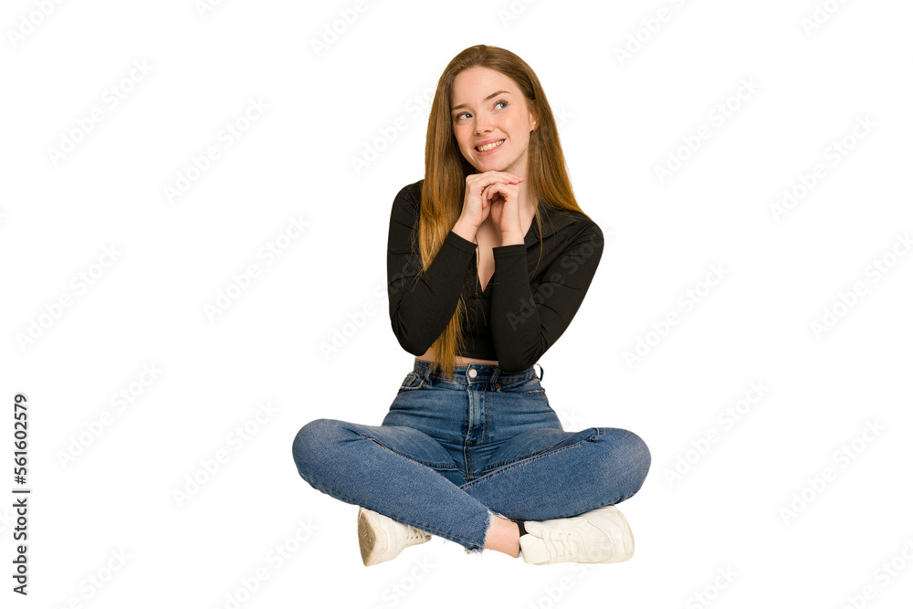 Young redhead woman sitting on the floor cut out isolated keeping two arms crossed, denial concept.