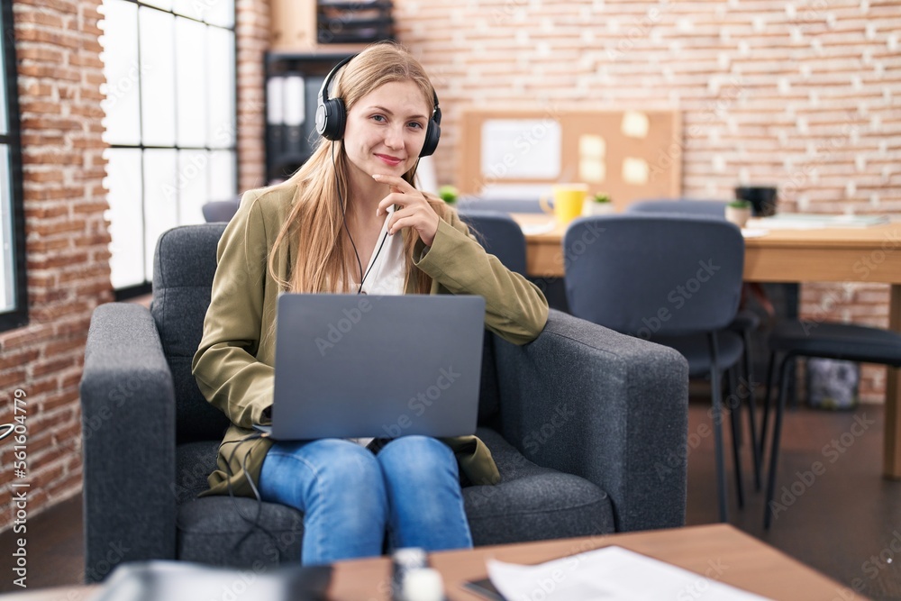 Young caucasian woman business worker using laptop and headphones at office Young caucasian woman business worker using laptop and headphones at office