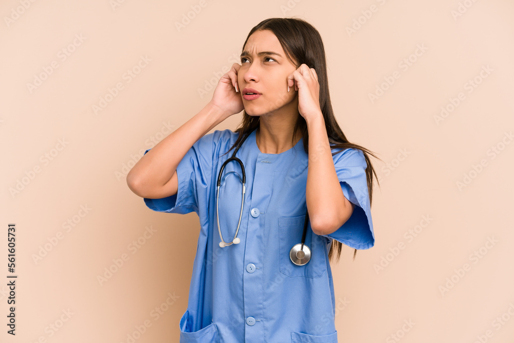 Young nurse colombian woman isolated covering ears with hands.