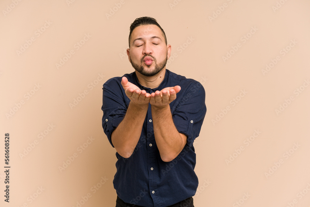 Adult latin man cut out isolated folding lips and holding palms to send air kiss. Adult latin man cut out isolated folding lips and holding palms to send air kiss.