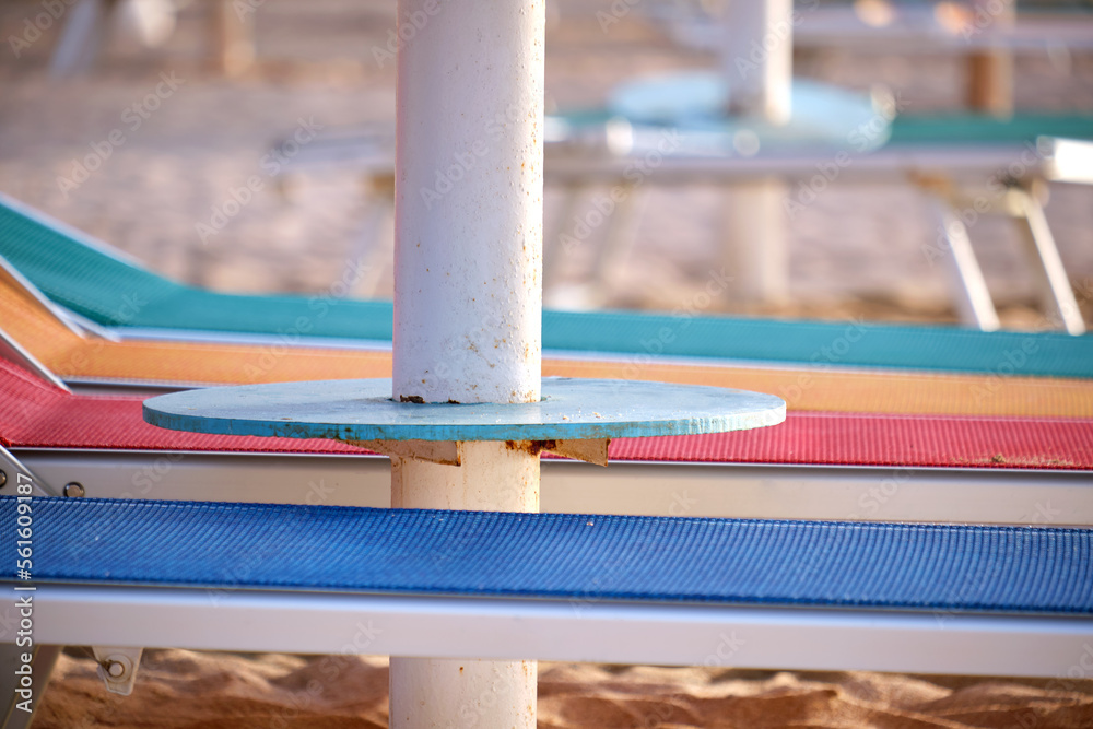 Empty deck chairs on sandy beach sea side in summer resort. Vacations and getaway concept