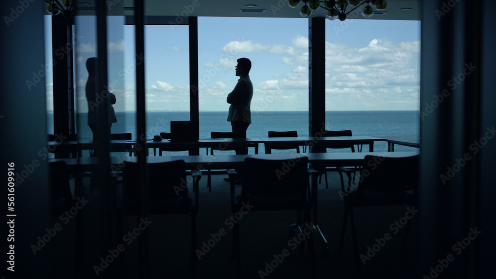 Businessman silhouette enjoying break in conference room. Manager going at pause Businessman silhouette enjoying break in conference room. Manager going at pause