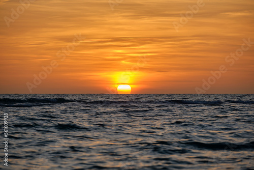 Ocean sunset. Big white sun on dramatic bright sky background  soft evening horizont over sea dark water