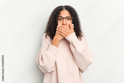 Young african american woman isolated on white background covering mouth with hands looking worried. © Asier