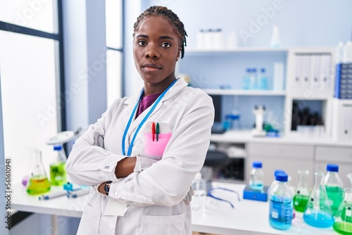 African american woman wearing scientist uniform standing with arms crossed gesture at laboratory