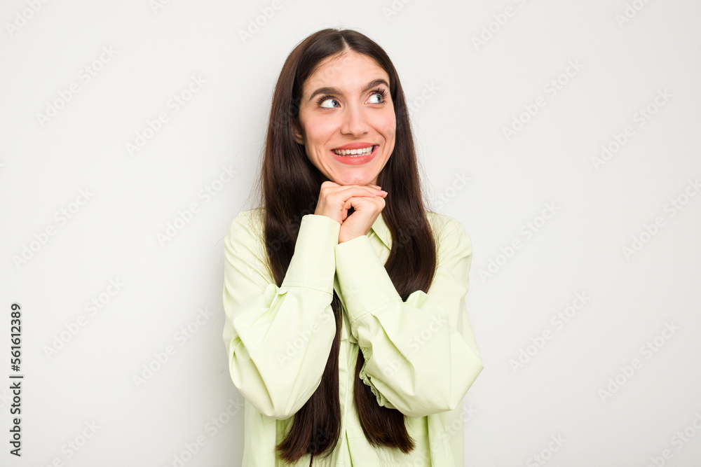 Young caucasian woman isolated on white background keeps hands under chin, is looking happily aside. Young caucasian woman isolated on white background keeps hands under chin, is looking happily aside.