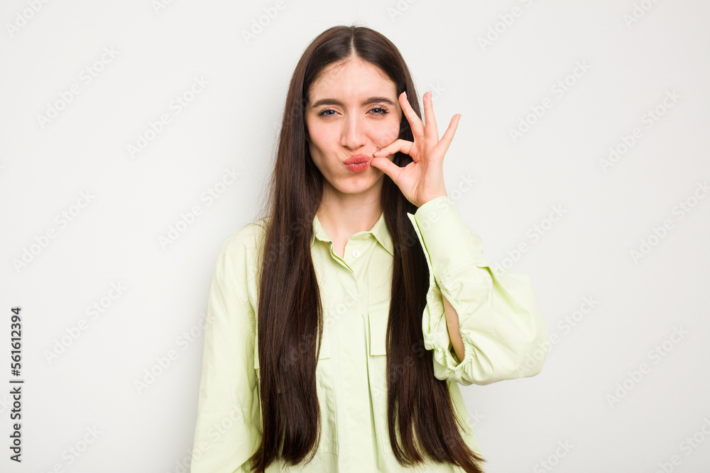 Young caucasian woman isolated on white background with fingers on lips keeping a secret. Young caucasian woman isolated on white background with fingers on lips keeping a secret.