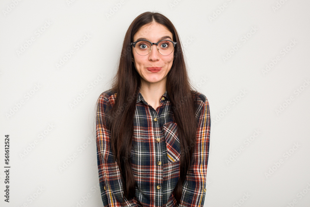 Young caucasian woman isolated on white background shrugs shoulders and open eyes confused. Young caucasian woman isolated on white background shrugs shoulders and open eyes confused.