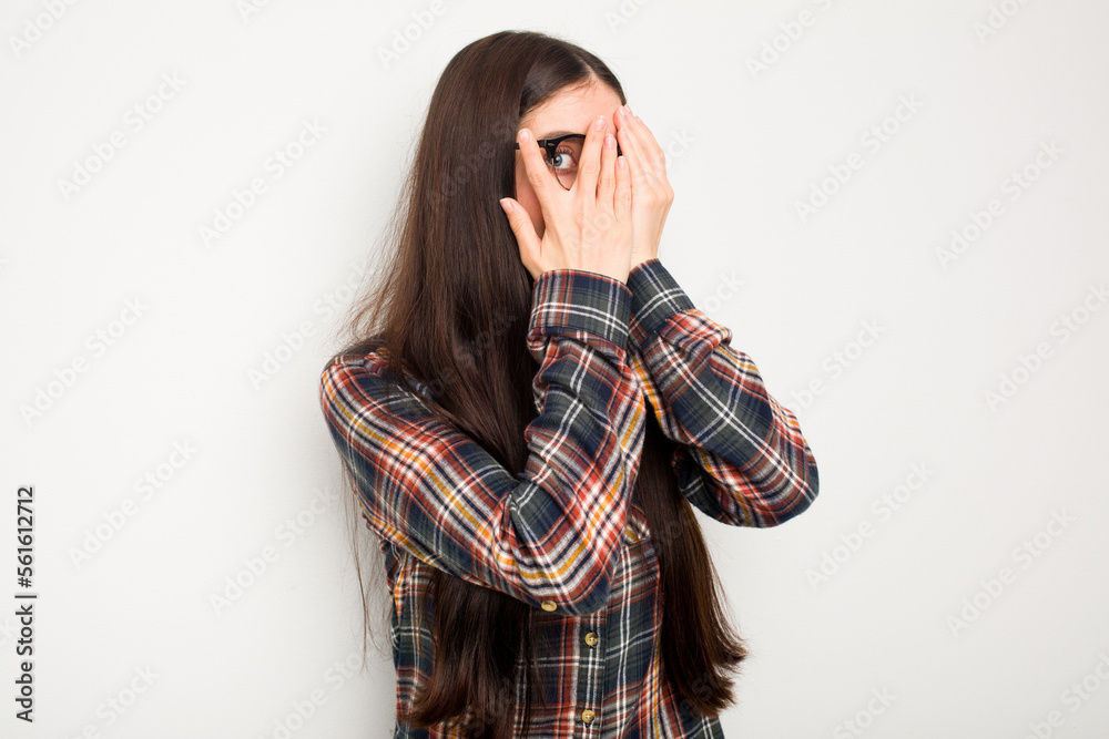 Young caucasian woman isolated on white background blink through fingers frightened and nervous. Young caucasian woman isolated on white background blink through fingers frightened and nervous.