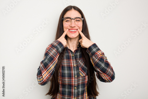 Young caucasian woman isolated on white background smiles, pointing fingers at mouth.