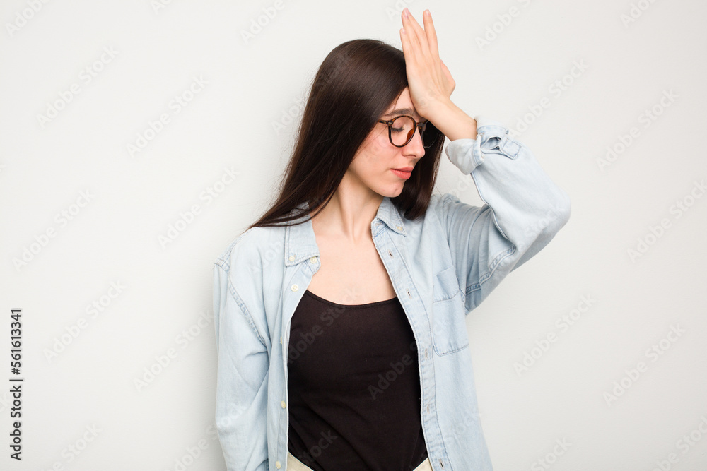 Young caucasian woman isolated on white background forgetting something, slapping forehead with palm and closing eyes. Young caucasian woman isolated on white background forgetting something, slapping forehead with palm and closing eyes.